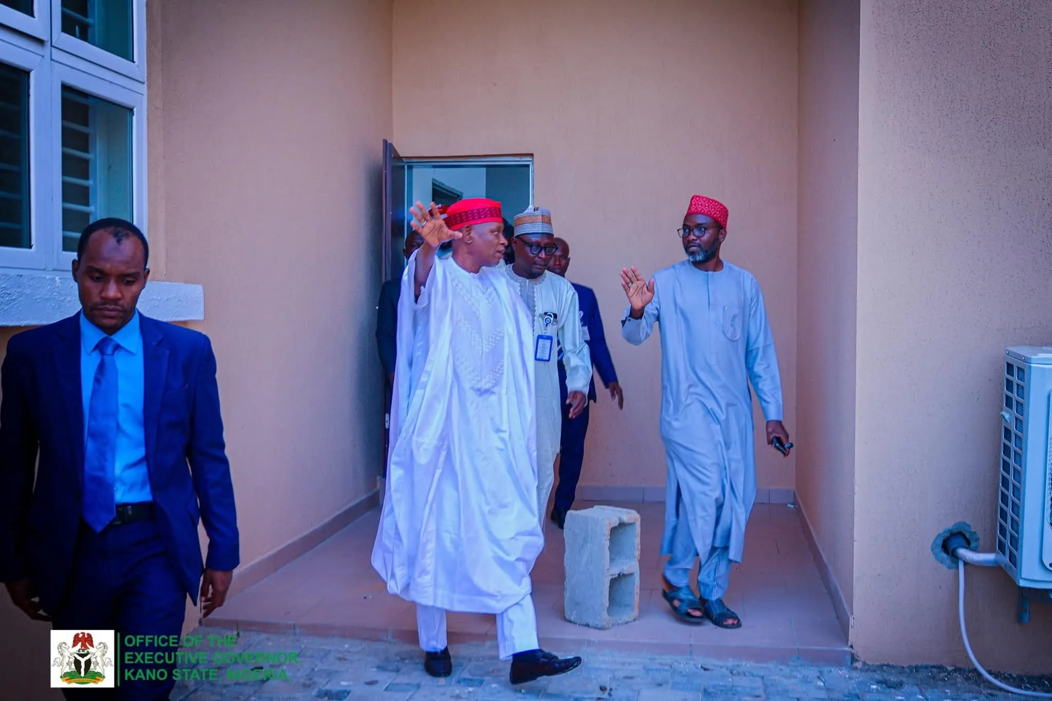Officials being received at the entrance of a state facility during a site visit.